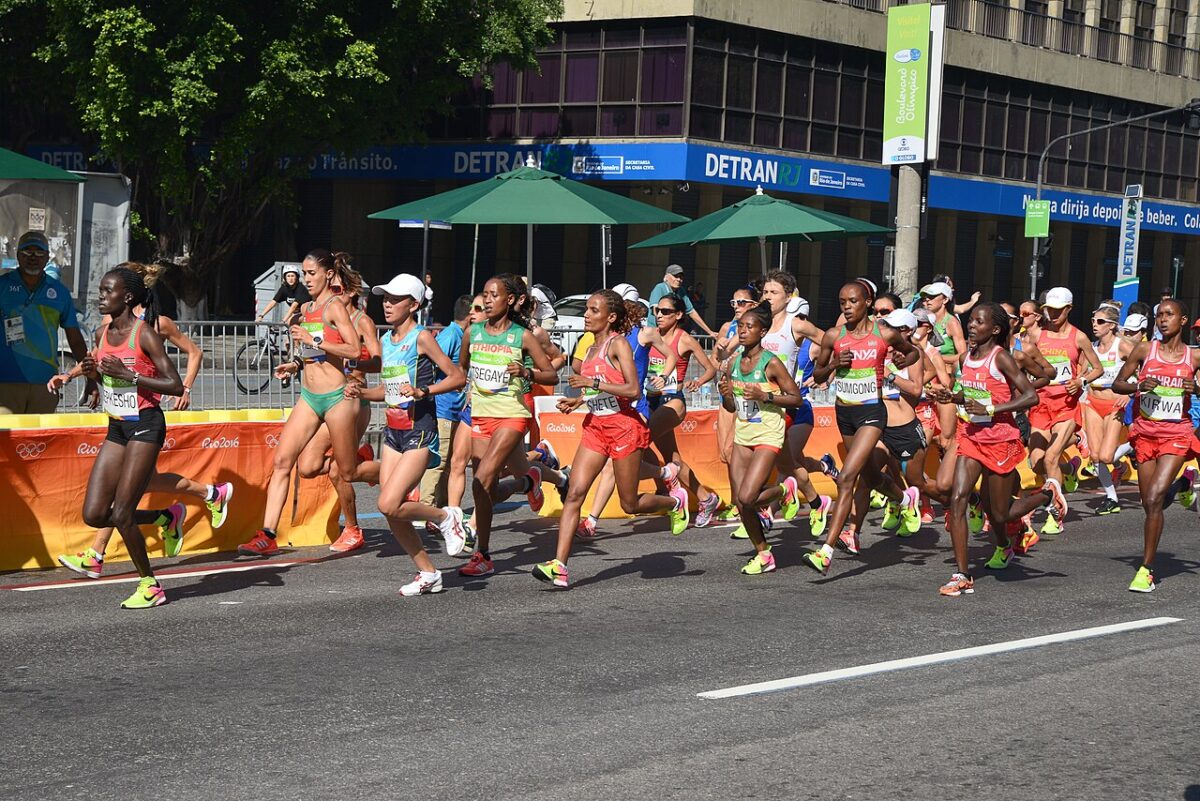 Coureurs de marathon au ravitaillement, illustrant l’hydratation sportif pour éviter la déshydratation